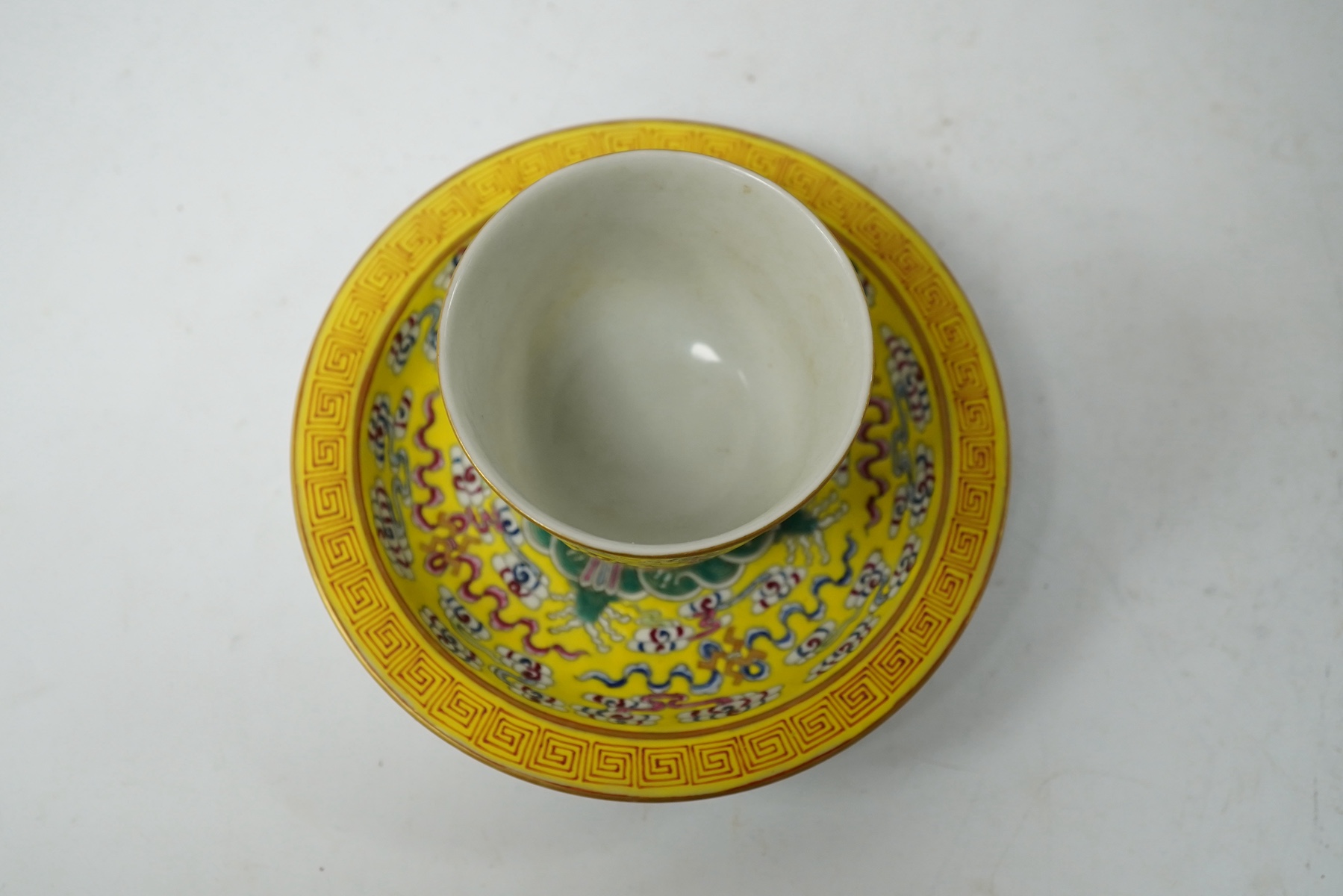 A Chinese porcelain yellow-ground tea cup and saucer, 13cm diameter. Condition - good